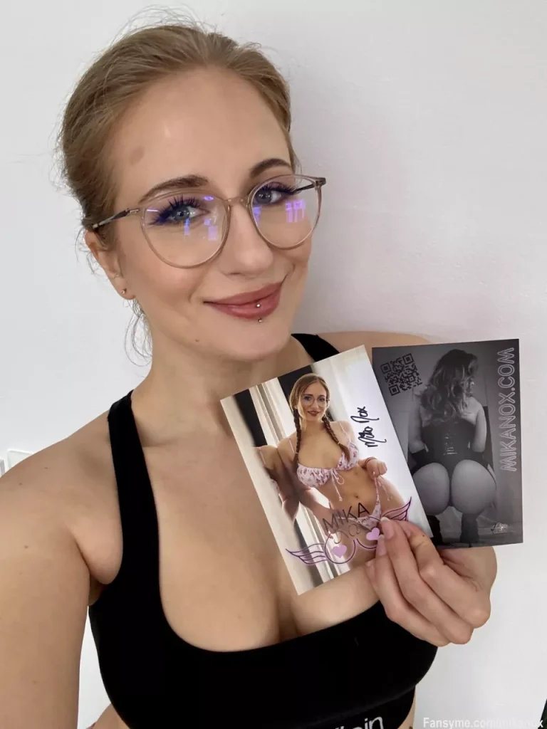 Mika Nox zeigt ein Beispiel ihrer persönlichen, handsignierten Autogrammkarte für Fans.
